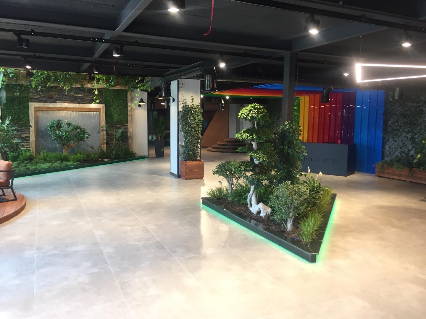 Yeşil duvarlar ve renkli panellerle tasarlanmış showroom lobisi